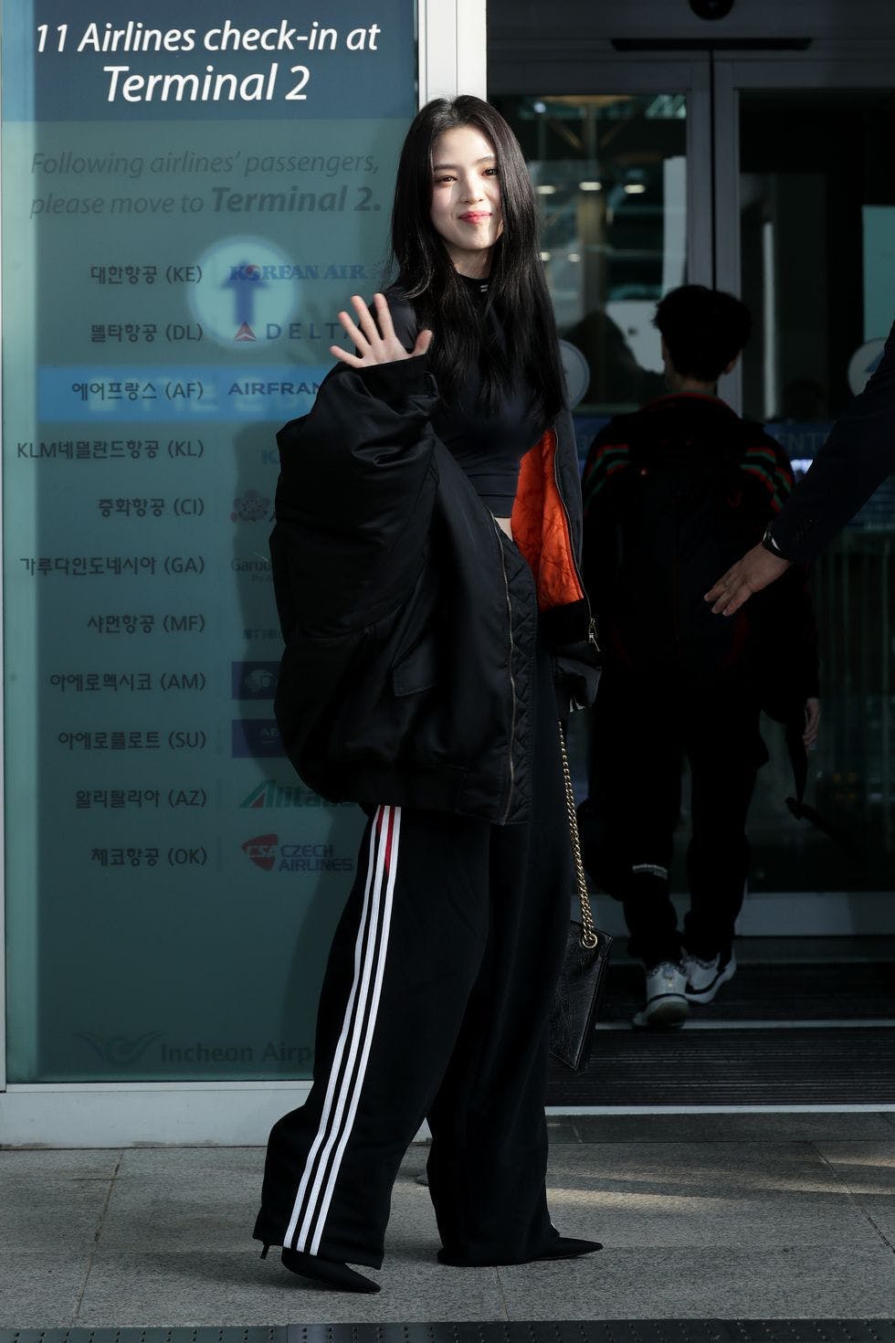 coat black hair person adult female woman walking jacket long sleeve handbag